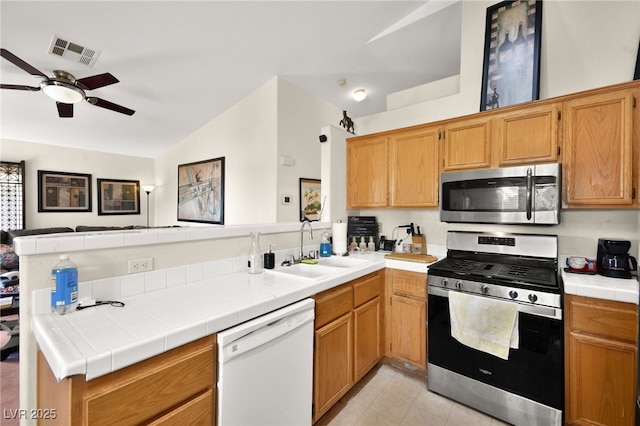 kitchen featuring visible vents, a sink, stainless steel appliances, a peninsula, and ceiling fan