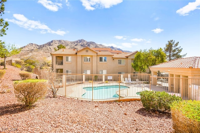 pool with a mountain view, a patio, and fence