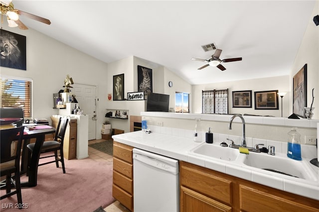 kitchen with visible vents, a sink, vaulted ceiling, dishwasher, and brown cabinets