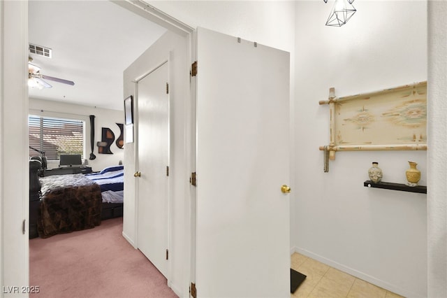 hallway with baseboards, visible vents, and carpet floors