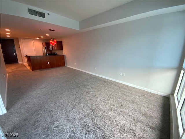 unfurnished living room with recessed lighting, carpet flooring, baseboards, and visible vents