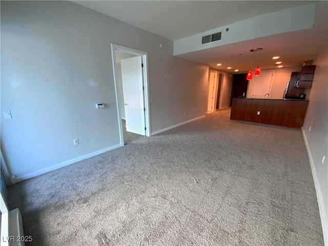 unfurnished living room featuring recessed lighting, visible vents, baseboards, and carpet floors