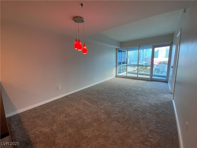 carpeted empty room featuring baseboards