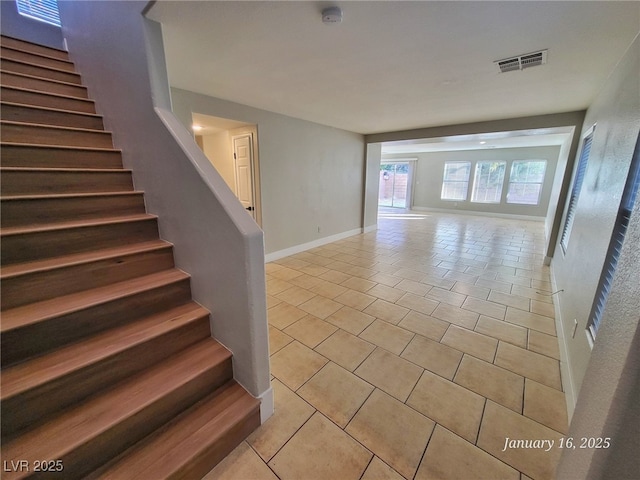 stairs with tile patterned floors, baseboards, and visible vents