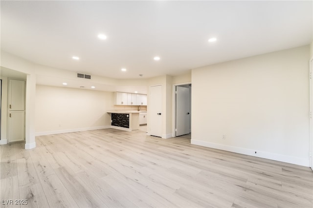 unfurnished living room featuring light wood-type flooring, recessed lighting, visible vents, and baseboards