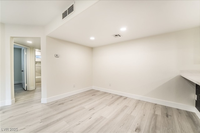 empty room with visible vents, baseboards, and light wood-style floors