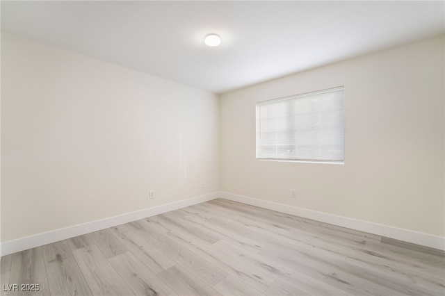 spare room with light wood-type flooring and baseboards