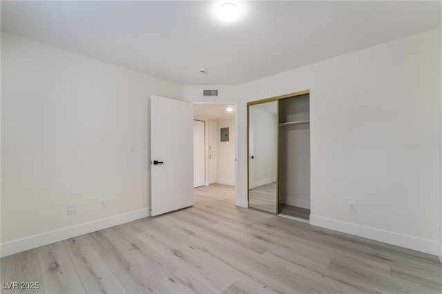 unfurnished bedroom featuring light wood finished floors, visible vents, a closet, and baseboards