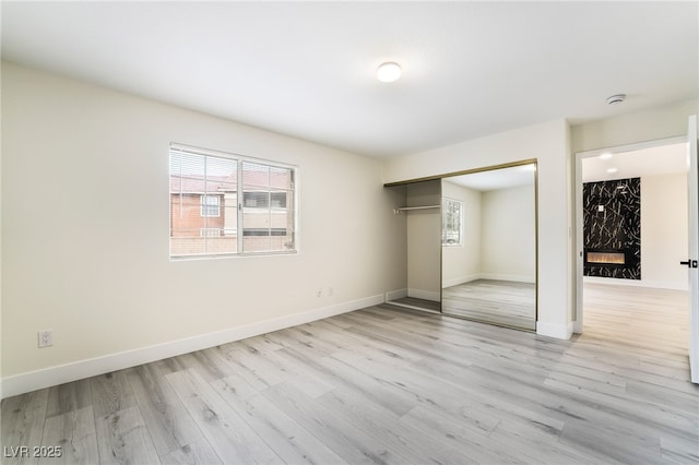 unfurnished bedroom featuring a closet, baseboards, and wood finished floors