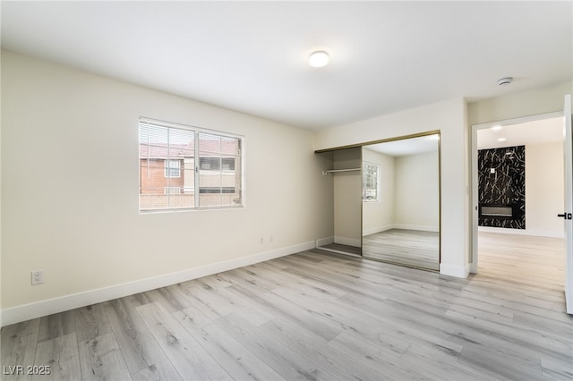 unfurnished bedroom with light wood-style floors, a closet, and baseboards