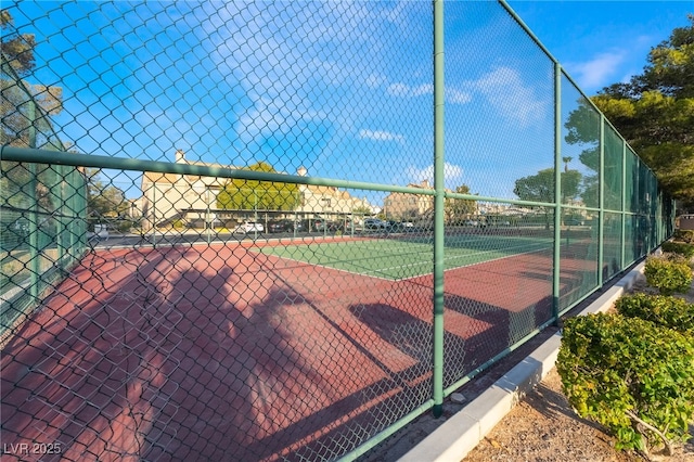 view of tennis court featuring fence