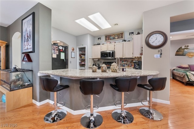 kitchen with stainless steel appliances, a kitchen breakfast bar, and a peninsula