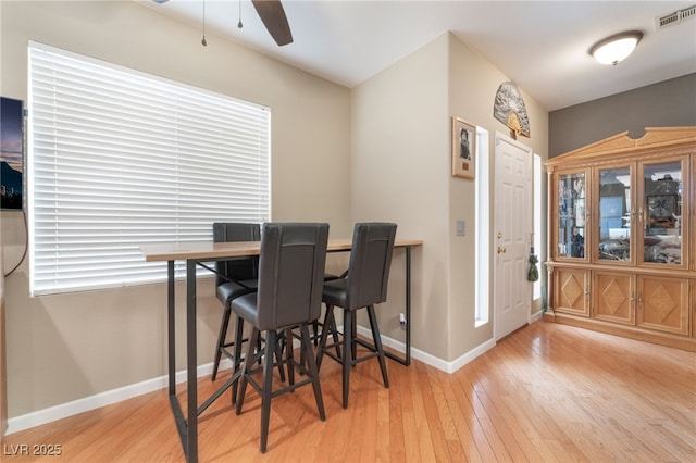 dining space featuring visible vents, ceiling fan, baseboards, and hardwood / wood-style flooring