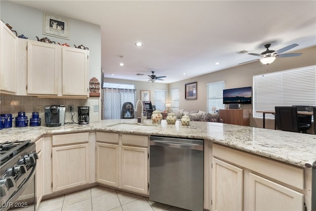 kitchen with open floor plan, gas range, dishwasher, light tile patterned flooring, and a sink