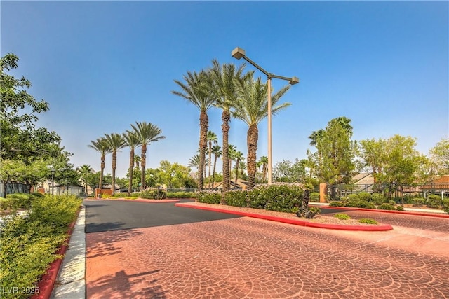 view of road with a gated entry and curbs