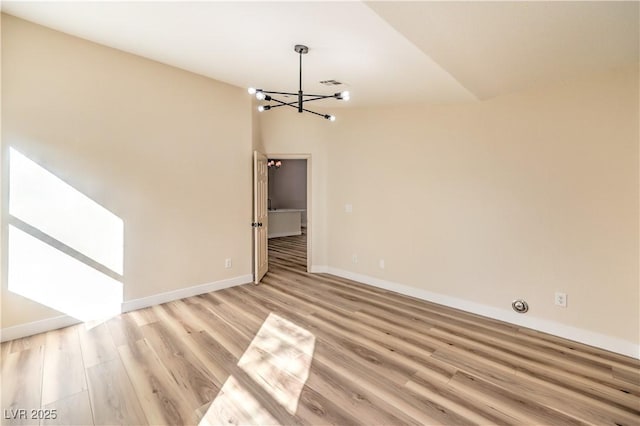 unfurnished dining area with visible vents, baseboards, light wood finished floors, vaulted ceiling, and a chandelier