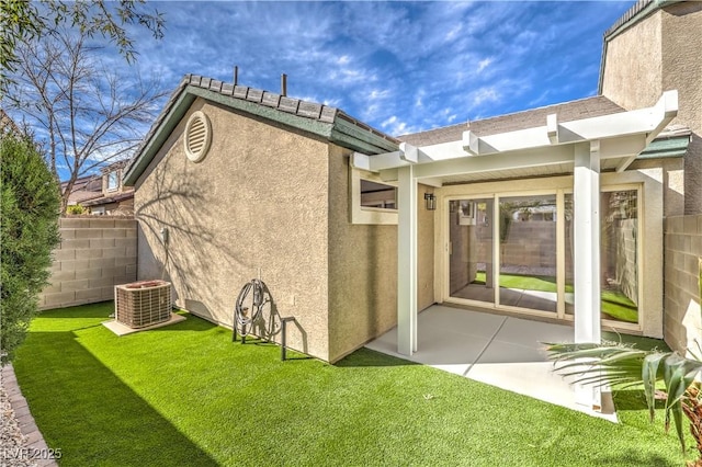 back of house with stucco siding, a patio, a lawn, and fence