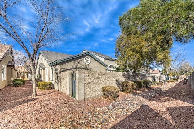 view of property exterior with fence and stucco siding