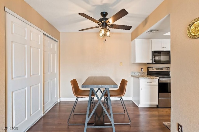 dining area with visible vents, baseboards, dark wood finished floors, and a ceiling fan