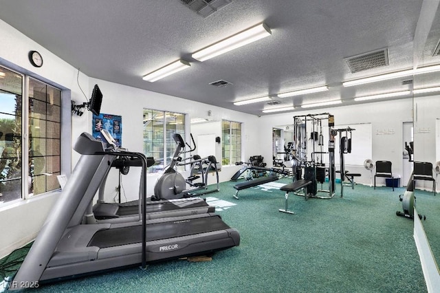 workout area with visible vents and a textured ceiling