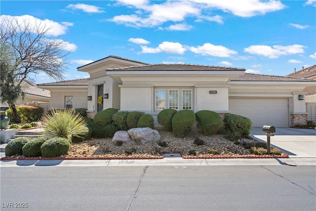 prairie-style house featuring an attached garage, driveway, and stucco siding