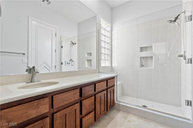 bathroom with tile patterned floors, a stall shower, and vanity