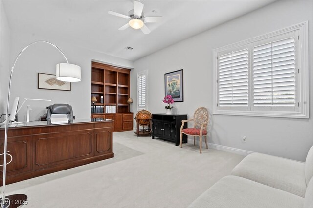 home office featuring light colored carpet, ceiling fan, and baseboards