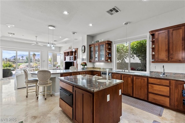 kitchen with open shelves, a raised ceiling, visible vents, a sink, and a peninsula