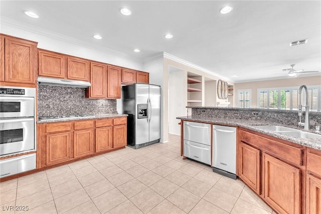 1596 Fieldbrook St, Henderson, NV 89052 - kitchen with appliances with stainless steel finishes, a warming drawer, under cabinet range hood, ornamental molding, and brown cabinetry