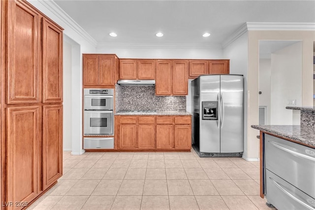 1596 Fieldbrook St, Henderson, NV 89052 - kitchen featuring stainless steel appliances, a warming drawer, under cabinet range hood, brown cabinetry, and decorative backsplash