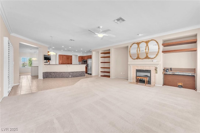 1596 Fieldbrook St, Henderson, NV 89052 - unfurnished living room with crown molding, a tiled fireplace, light colored carpet, ceiling fan, and recessed lighting
