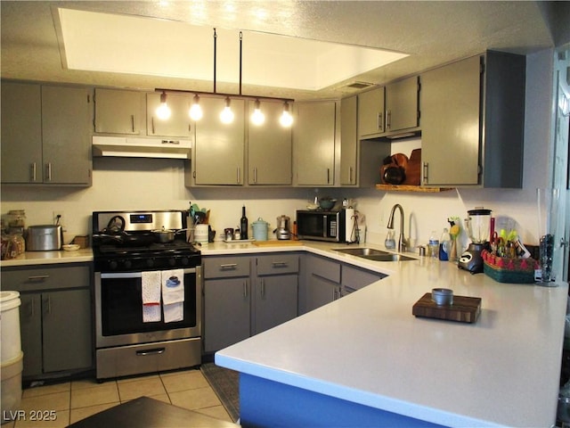 kitchen with gray cabinets, under cabinet range hood, a sink, stainless steel appliances, and light tile patterned flooring