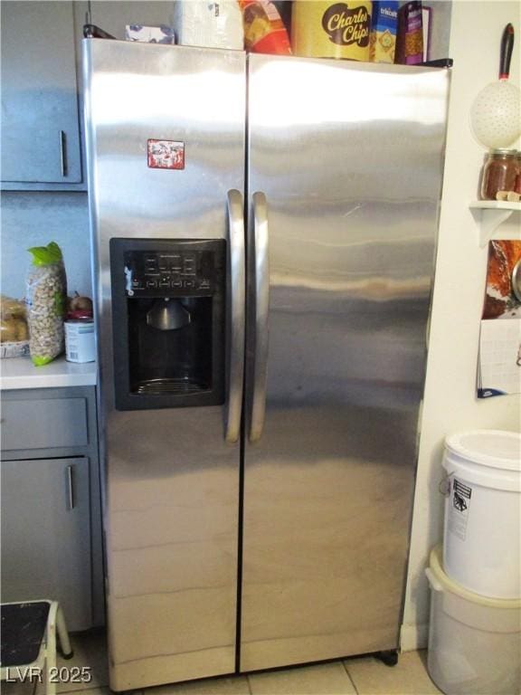 interior details with gray cabinetry, light countertops, and stainless steel fridge with ice dispenser