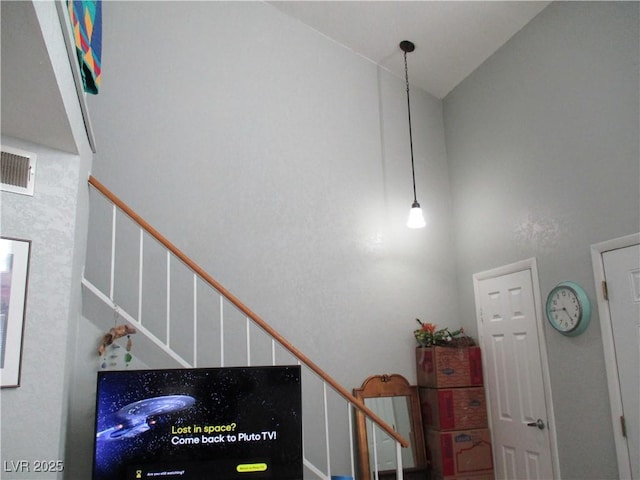 stairway with visible vents and high vaulted ceiling