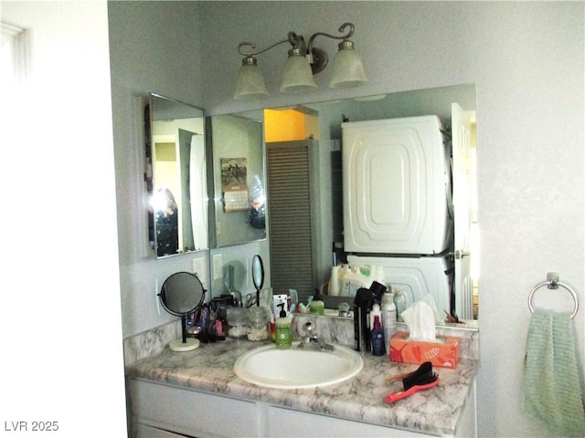 bathroom with stacked washer and clothes dryer and vanity