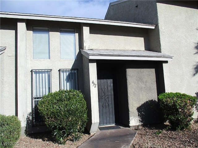 entrance to property featuring stucco siding