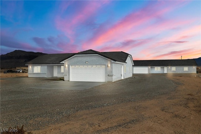 ranch-style home with stucco siding, an attached garage, and concrete driveway