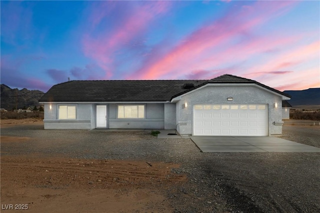 single story home with an attached garage, driveway, and stucco siding