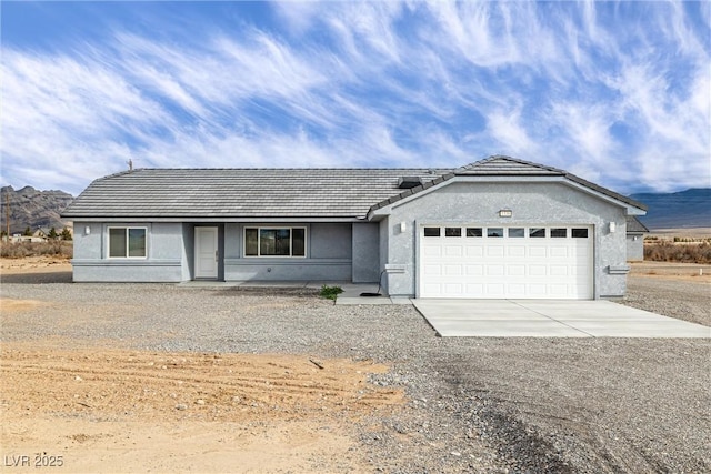 ranch-style home featuring stucco siding, concrete driveway, an attached garage, and a tiled roof