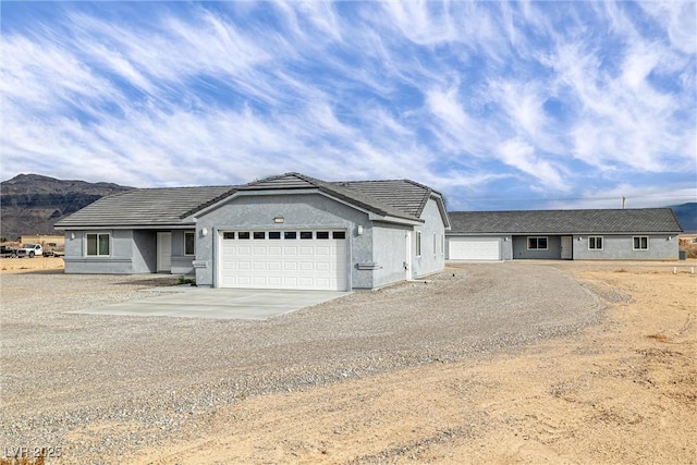 single story home with stucco siding, driveway, and an attached garage