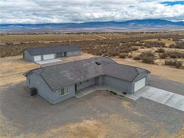 drone / aerial view featuring a mountain view and a desert view