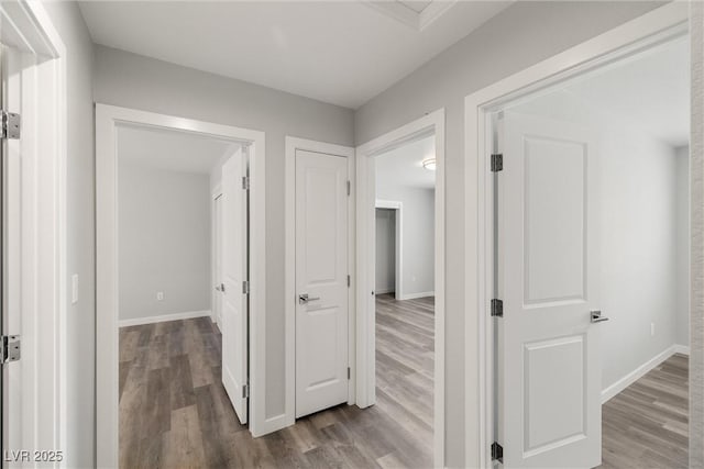 hallway featuring baseboards and wood finished floors