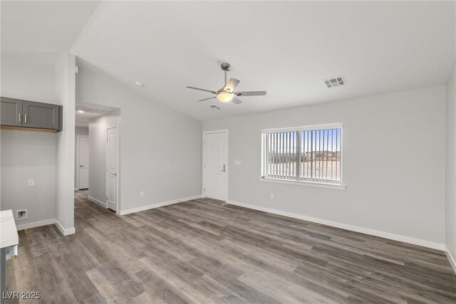 unfurnished living room featuring visible vents, lofted ceiling, wood finished floors, baseboards, and ceiling fan