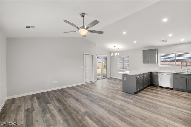 kitchen featuring visible vents, gray cabinets, a peninsula, stainless steel dishwasher, and a sink