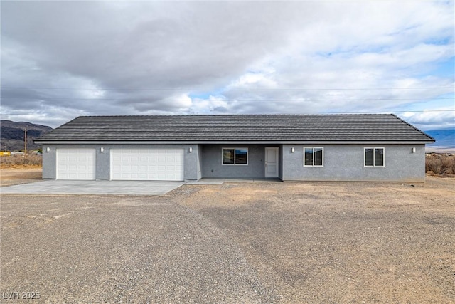 ranch-style house with stucco siding, driveway, and an attached garage