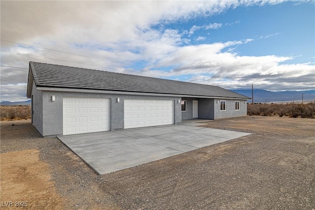 ranch-style home featuring stucco siding, driveway, and a mountain view