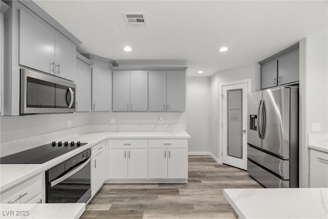 kitchen featuring black appliances, recessed lighting, visible vents, and light wood-type flooring