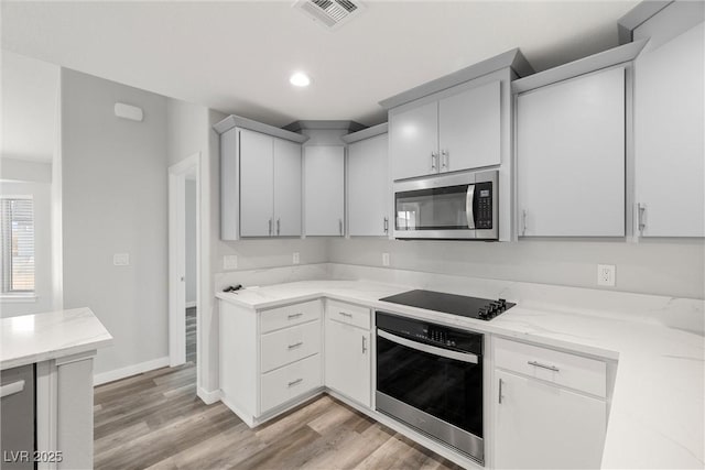 kitchen featuring baseboards, visible vents, recessed lighting, appliances with stainless steel finishes, and light wood-type flooring