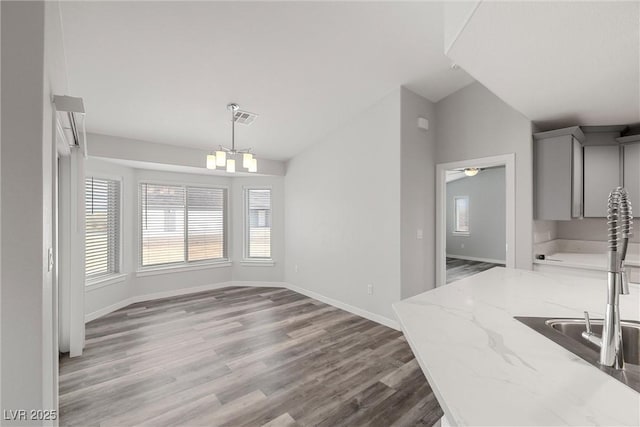 dining area featuring visible vents, wood finished floors, baseboards, and vaulted ceiling