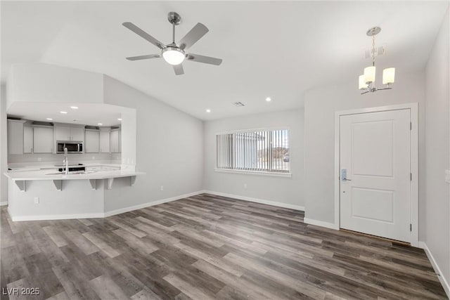 unfurnished living room featuring visible vents, baseboards, dark wood finished floors, vaulted ceiling, and recessed lighting